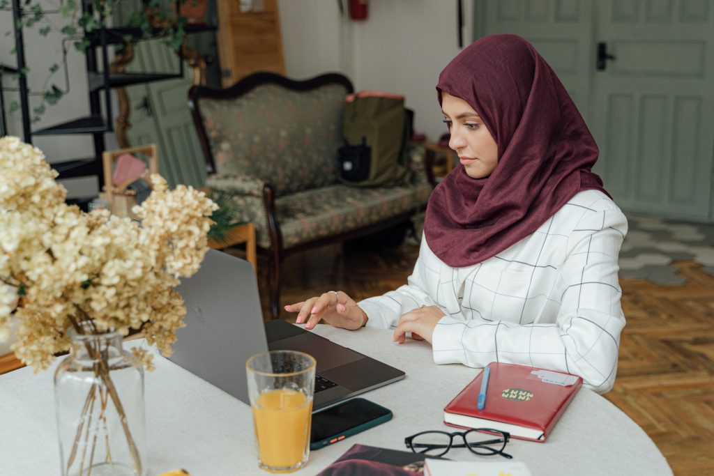 woman sitting at a table on laptop computer