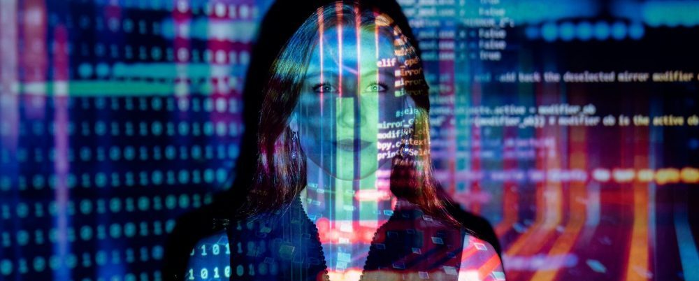 woman in front of a wall with a colorful data projection