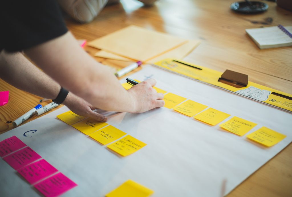 person writing out a strategy on a sticky note