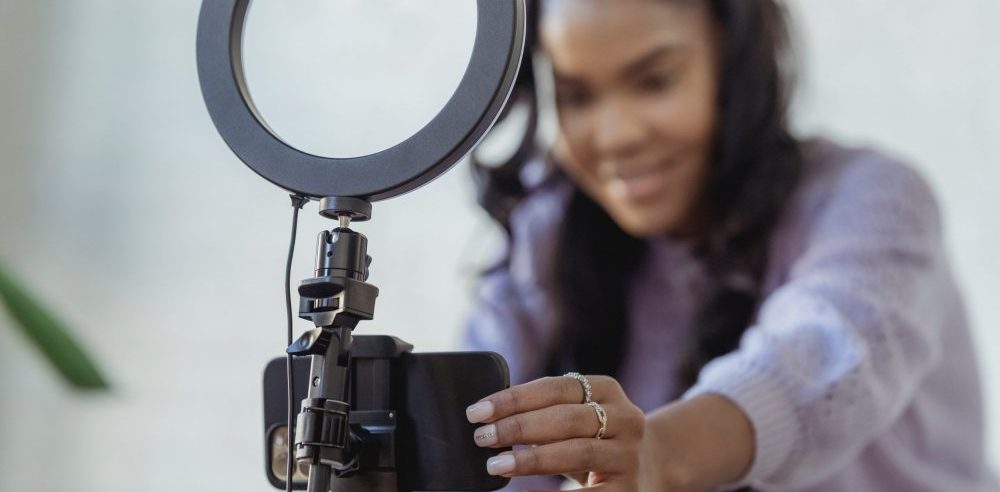 young woman setting up smartphone to record a video