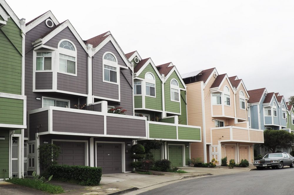 row of grey, green and tan houses