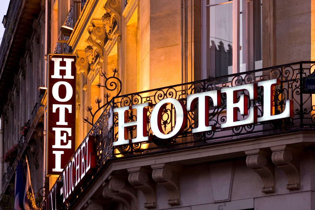 Illuminated Parisian hotel sign taken at dusk