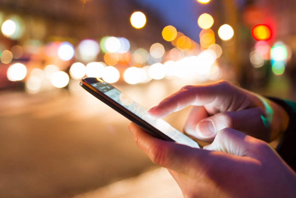 person outside using their smartphone to look at an app