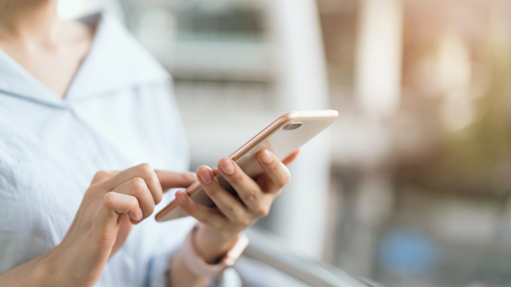 woman using smartphone on staircase in public areas, during leisure time. The concept of using the phone is essential in Google Ads and shopping.