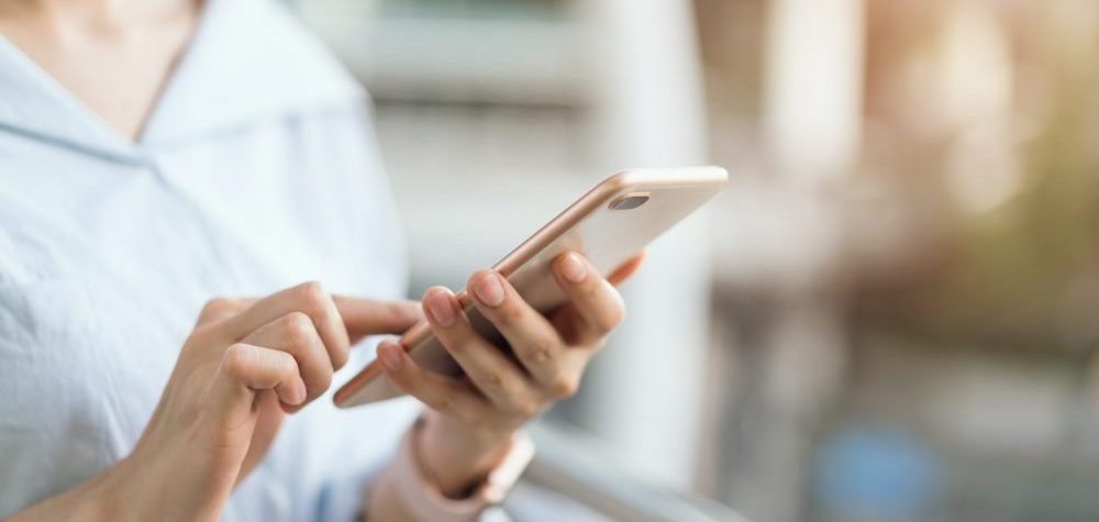 woman using smartphone on staircase in public areas, during leisure time. The concept of using the phone is essential in Google Ads and shopping.