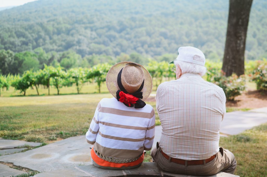 two seniors sitting together outside